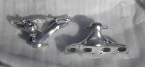 1997 Ford Taurus - Two chrome exhaust manifolds are displayed on a white background. The registry claims they are from a 1997 Ford Taurus.