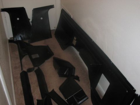 1991 Ford Bronco - Various black car interior trim pieces are laid out on a carpeted floor.