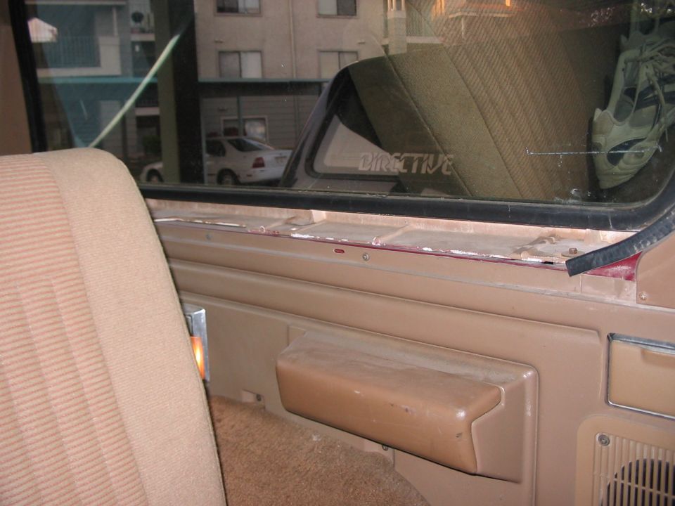 1991 Ford Bronco interior showing tan seats and door panel with a small orange interior light