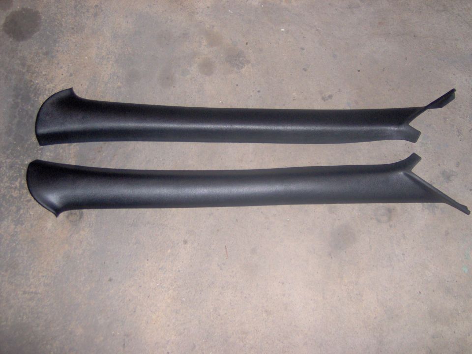 Two black plastic trim pieces on a concrete floor