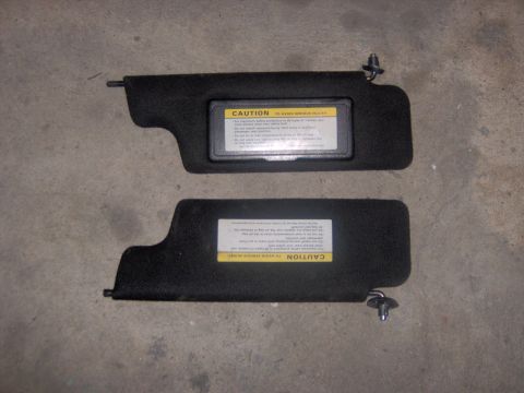 1994 Ford Probe - Two black sun visors are shown, each with a yellow caution label detailing safety warnings.