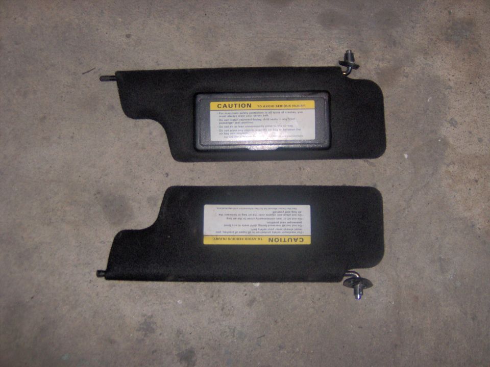 Pair of black sun visors with caution labels