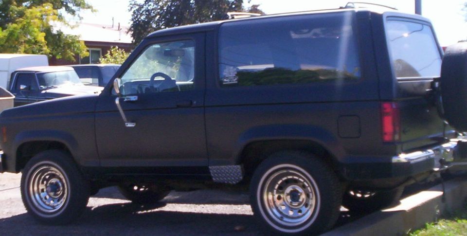Black two-door Ford Bronco II SUV parked in profile on a driveway