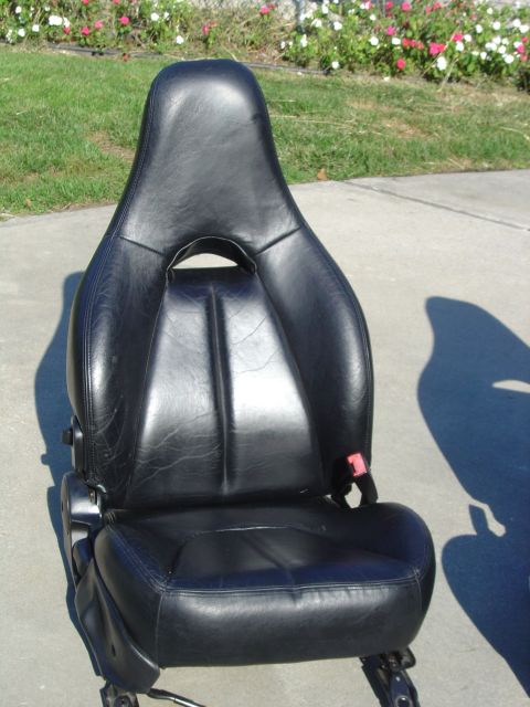 1995 Ford Probe - A single black leather car seat is shown outdoors, with a red seatbelt buckle visible.