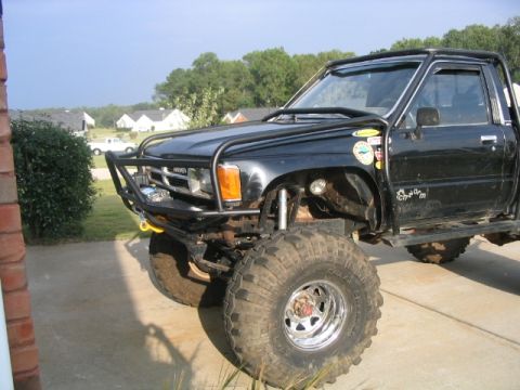 1986 Ford F-150 - This modified truck features large off-road tires and a custom brush guard, suggesting it's built for terrain.