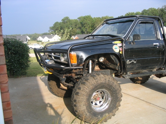 Black lifted truck with off-road tires and brush guard