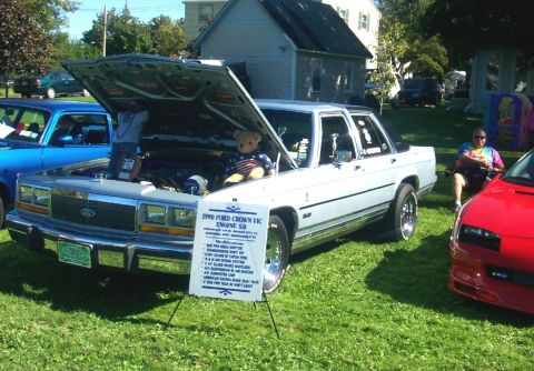 1979 Ford F-150 - A white 1990 Ford Crown Victoria is displayed with its hood open, revealing the engine compartment.