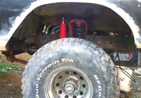 1979 Ford F-150 - Close-up of a vehicle's rear wheel well showing suspension modifications and a large tire.
