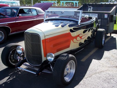 1972 Ford Ranchero - A custom hot rod with flame graphics sits parked next to a dumpster, with another vehicle in the background.