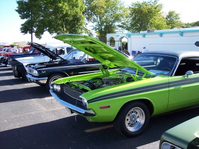 1972 Ford Ranchero - Several cars are parked in a lot, with their hoods open, under a bright sky.