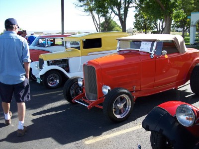 1972 Ford Ranchero - A line of classic cars, including a bright red convertible hot rod, are displayed at an outdoor event.