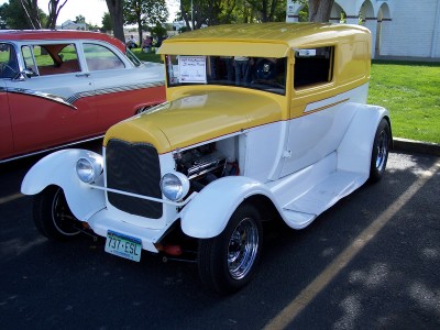 1972 Ford Ranchero - A vintage panel truck with a two-tone paint scheme is parked outdoors next to another classic car.
