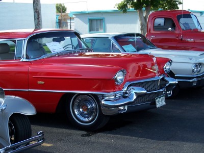 1972 Ford Ranchero - A red 1955 Cadillac Coupe de Ville is parked in front of other cars and a red truck.