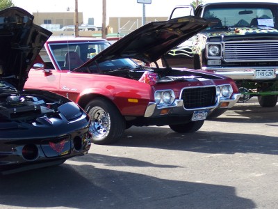 1972 Ford Ranchero - Three vehicles are parked outside with their hoods open, suggesting a car show or gathering.