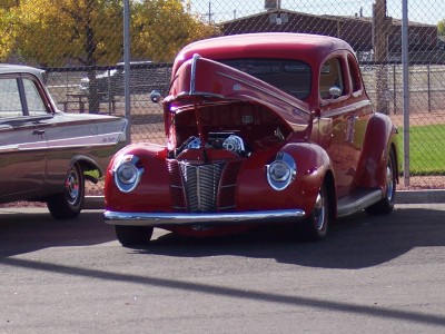 1972 Ford Ranchero - A classic red coupe is parked next to another vintage vehicle, with its hood open revealing the engine.