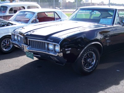 1972 Ford Ranchero - A black 1969 Oldsmobile 442 W-31 is parked next to another vehicle at an outdoor event.