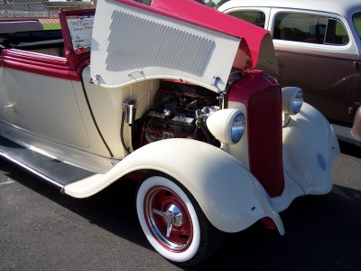 1972 Ford Ranchero - Rear view of a customized 1930s Ford hot rod with its hood open and a large red ribbon on the trunk.