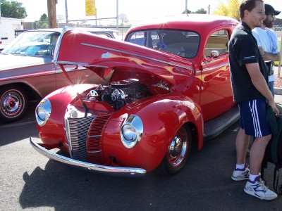 1972 Ford Ranchero - Custom hot rod pickup truck at a car show, with a bystander nearby. Another vehicle is visible in the background.