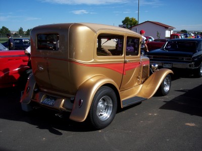1972 Ford Ranchero - A customized hot rod with a gold paint job and flame graphics is parked outdoors.