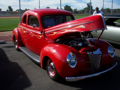 1972 Ford Ranchero - A bright red hot rod coupe is parked outdoors with its hood open, revealing the engine.