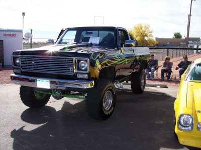 1972 Ford Ranchero - A custom pickup truck with flame decals sits parked outdoors next to another vehicle.