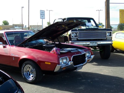 1972 Ford Ranchero - A red 1970s Ford Ranchero is parked next to a black pickup truck, both with hoods open.
