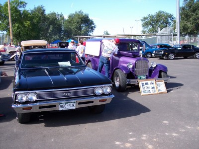 1972 Ford Ranchero - A black 1966 Chevrolet Chevelle SS is parked in front of a purple hot rod truck at an outdoor car show.