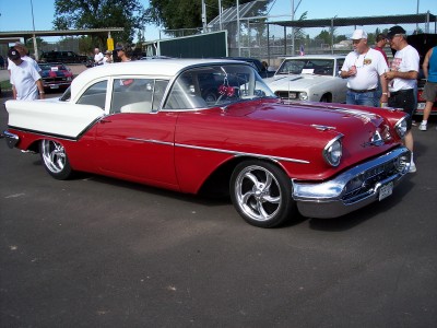 1972 Ford Ranchero - A classic red and white coupe with custom wheels is displayed at an outdoor event.