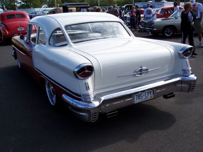 1972 Ford Ranchero - A classic two-tone Oldsmobile 88 is parked at an outdoor car show with other vehicles visible.