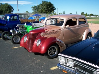 1972 Ford Ranchero - A custom hot rod sedan with flame graphics is parked alongside other vehicles at an outdoor event.