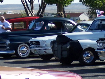 1972 Ford Ranchero - A lineup of vintage automobiles are parked together under trees on a sunny day.