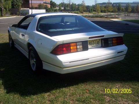 1988 Chevrolet Camaro - A white 1988 Chevrolet Camaro is shown from the rear 3/4 angle, parked on a grassy area.