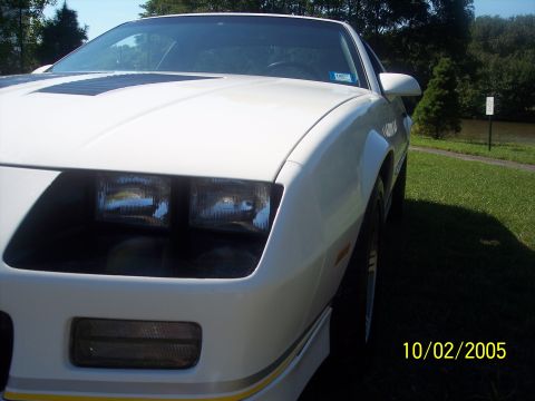 1988 Chevrolet Camaro - Front view of a white 1988 Chevrolet Camaro parked on grass near water.