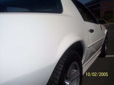 1988 Chevrolet Camaro - Rear view of a white 1988 Chevrolet Camaro, focusing on the quarter panel and wheel.
