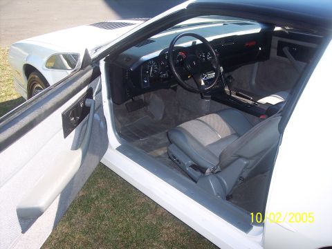 1988 Chevrolet Camaro - The interior of a white 1988 Chevrolet Camaro is shown with the driver's door open.