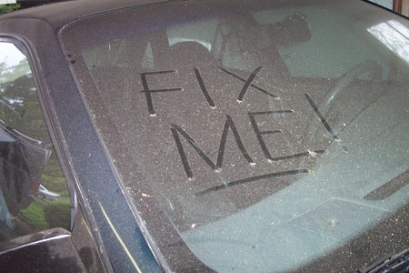 1995 Ford Taurus - The words 'FIX ME!' are written in the dust on a car's windshield.