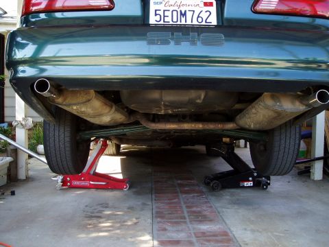 1993 Ford Taurus - Underside view of a 1993 Ford Taurus SHO, showing the exhaust system and rear suspension while on jacks.