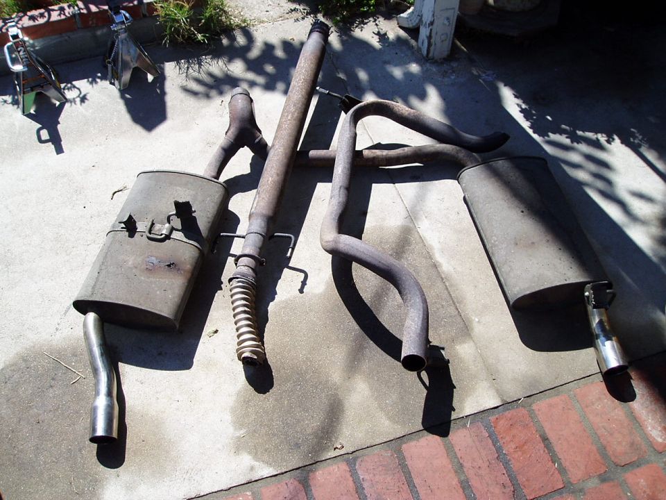 exhaust pipes and mufflers laid out on concrete