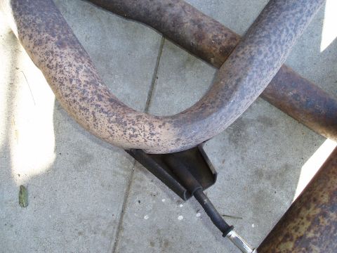 1993 Ford Taurus - Close-up view of corroded exhaust pipes and a mounting bracket.