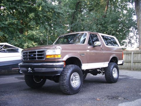 1993 Ford Bronco - This lifted 1993 Ford Bronco features large off-road tires and a two-tone brown and white paint scheme.