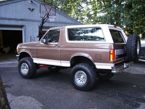 1993 Ford Bronco - This lifted Ford Bronco features a two-tone paint job and a spare tire mounted on the rear.