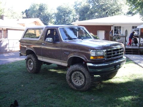 1993 Ford Bronco - This lifted Ford Bronco is parked in a residential yard, showing off its off-road tires.