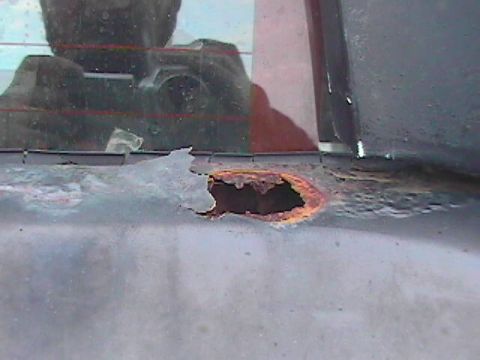 1989 Ford Bronco - A significant rust hole is visible on the vehicle's body, indicating poor condition.