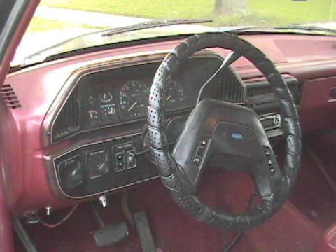 1989 Ford Bronco - The interior of a vehicle, a dashboard with gauges, a steering wheel, and radio controls.