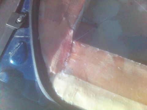 1994 Ford Probe - Close-up of blue car interior trim with visible stitching and a black hinge.