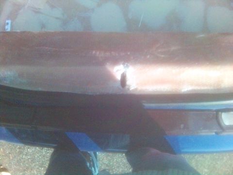 1994 Ford Probe - The rear bumper of a vehicle shows damage and is covered with blue tape.