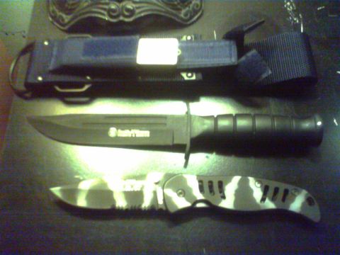 1990 Ford Ranger - A collection of knives, including a fixed-blade knife in a sheath and a folding knife with a camouflage pattern.