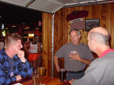 1986 Ford Mustang - People gathered in a bar, with a woman in uniform visible in the background.