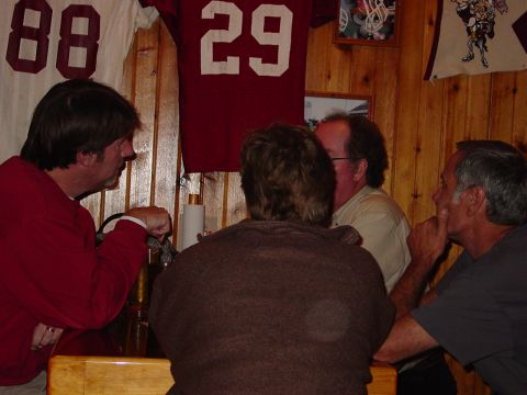 1986 Ford Mustang - People gathered around a table in a room decorated with sports memorabilia.