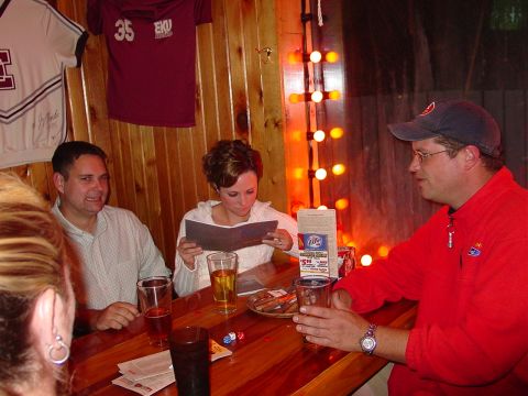 1986 Ford Mustang - A group of friends enjoy drinks and conversation at a bar, with sports jerseys adorning the wood-paneled wall.